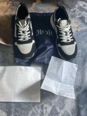 Dlor B22 sneakers svart/vit - Säljer ett par Dlor B22 sneakers i svart och vitt med chunky sula. Skorna har mesh och mockadetaljer, vita skosnören och en modern, sportig design. Kommer med originalpåse och dokumentation. Perfekta för dig som vill ha en lyxig och trendig lo.