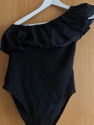 Volang body  - Svart body med volang detalj 