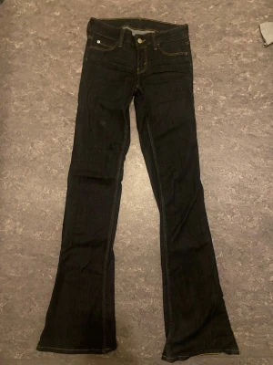 Mörkblå bootcut jeans - Lågmidjade mörkblå jeans från cheap monday i storlek 27/34