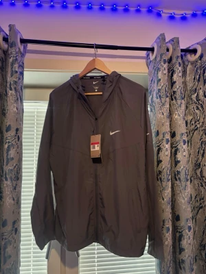 Nike svart träningsset med huva och byxa  - Säljer ett svart träningsset från Nike med jacka och byxor. Jackan har huva, dragkedja och Nike-logga på bröstet. Byxorna har resår i midjan och Nike-logga på benet. Perfekt för löpning eller gym. Materialet är lätt och andas.