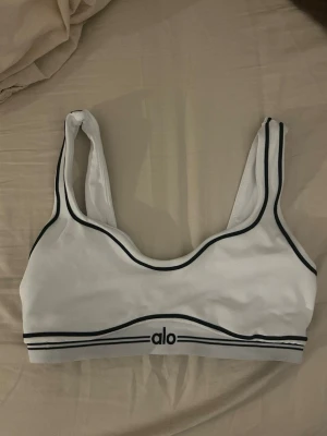 Vit sport-bh från Alo med svarta detaljer - Säljer den för den har blivit liten i storlek💕