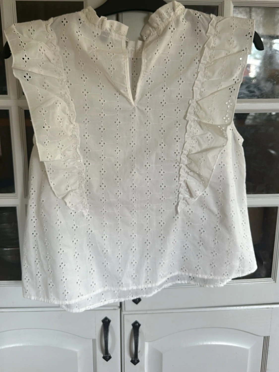 Vit ärmlös blus med volangdetaljer