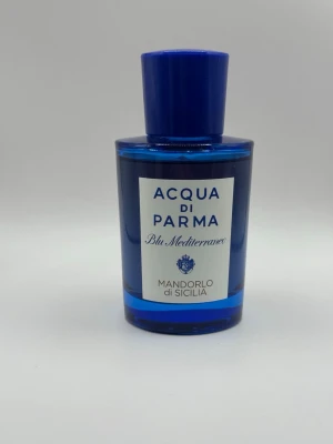 Acqua di Parma Mandorlo di Sicilia - Acqua di Parma Mandorlo di Sicilia Blu Mediterraneo är en parfym i en elegant, rund blå glasflaska med matchande blått lock. Flaskan har en stilren etikett framtill med blå text och detaljer. Doften är inspirerad av Medelhavet och har en exklusiv känsla. Endast testad med några sprut. 