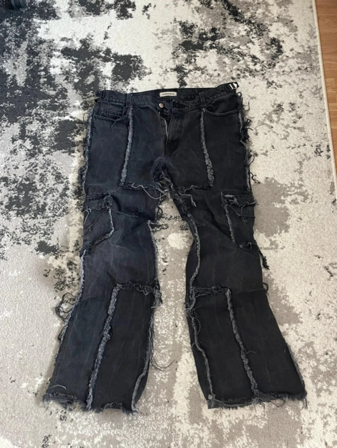 Svarta patchwork jeans med råa kanter