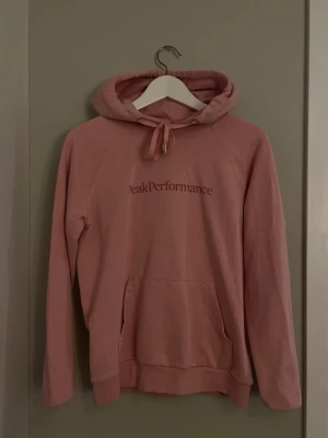 Rosa hoodie från Peak Performance - Säljer en rosa hoodie från Peak Performance med logga på bröstet.