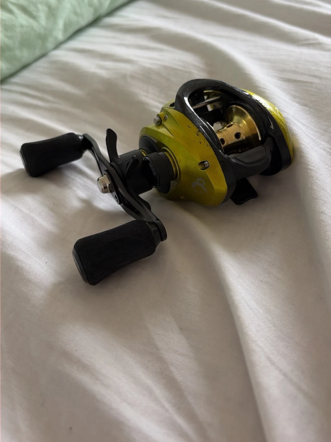 Gul baitcasting-rulle med svarta detaljer