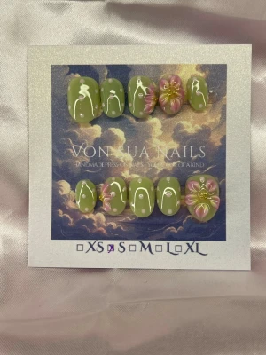 Joy (S);ExtraShortOval  - Unika handgjorda press-on naglar i grönt med rosa prickar och handgjorda 3D-blommor i rosa och gult. Extra korta Ovala former och cool design som sticker ut. Perfekt för dig som vill ha något extra på naglarna. Kommer i storlek S: 15 mm, 11,5 mm, 12 mm, 11 mm, 9 mm .