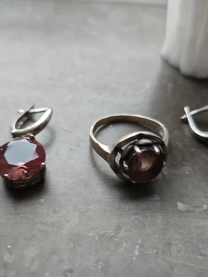 Silverring med brun sten .925 äkta silver - Säljer en stilren silverring med en rund, röd sten i fattning. Ringen har en klassisk design med en något högre infattning som ger ett elegant intryck. Perfekt för dig som gillar smycken med färg och enkelhet.