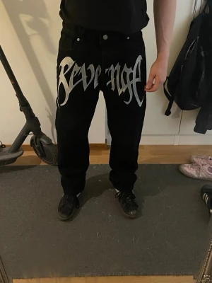Svarta jeans med ”REVENGE” brodering - Svarta jeans med Revenge brodering. Raka ben och klassisk femficksmodell. Dock är det bara revenge som det står, inte säker att de faktiskt är de eller inte, men spelar inte så stor roll för kvaliten är perfekt och jag säljer dem billigt! Ställ frågor om de behövs! Det står att storleken är M, jag skulle gissa på att det är runt 30 i midja o längd👍 använda typ 4-5 gånger