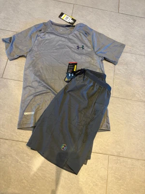 Grå Underarmour set - Helt nya gråa svarta Underarmour  summer set som passar perfekt för den kommande sommarn.Dressen passar S där den sitter lite mindre!