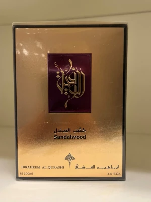 Ibraheem Al Qurashi Sandalwood Parfym 100 ml - Lyxig Eau de Parfum från Ibraheem Al Qurashi med doft av sandelträ. Flaskan rymmer 100 ml och kommer i en elegant guld- och lila förpackning med arabiska detaljer. Perfekt för dig som gillar varma, träiga dofter.