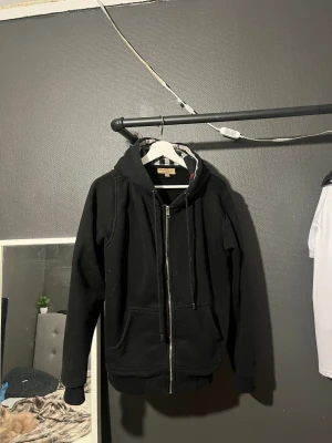 Svart hoodie från Burberry - Säljer en svart burberry zip up då den kntr används längre. Den är i fint skick. Storlek L men passar Mig som är 183 lång och har m. Kontakta via frågor. 