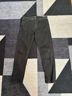 Svarta raka jeans från Jack & Jones - Säljer ett par svarta jeans från Jack & Jones med klassisk femficksmodell och raka ben. Jeansen har normal midja och är tillverkade i ett mjukt bomullsmaterial med lite stretch. Perfekta till en avslappnad och stilren look.                                               W31 L34