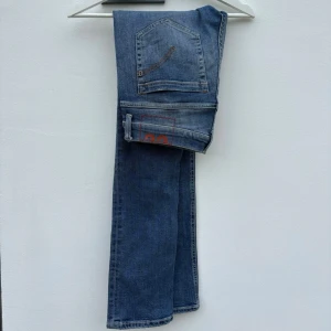 Dondup George - Tjena! Ljusblå tvättade jeans från märket Dondup i modellen; ”George”. Hetaste jeansen på marknaden just nu. (Size: 32)  (Skick: 5/5)  (Retail: 3500kr)  (Vårt pris: 799kr). (Mått: A = 41cm, B = 24cm, C = 80cm