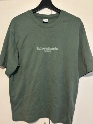 Grön t-shirt från Bershka - Snygg grön t-shirt från Bershka med trycket. Klassisk rund halsringning och avslappnad passform. Perfekt för en chill och trendig look.