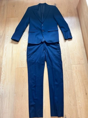 Mörkblå kostym med kavaj och byxor från Brothers Riley - Jag säljer nu min eleganta mörkblåa kostym från Brothers Riley i st 48. Kostym är slim fit och jag säljer den för att den nu blivit för liten. Den är endast använd vid fåtal tillfällen och i toppen skick. Har du några frågor eller funderingar är det bara att höra av sig. Priset är ej huggit i sten🙌🙌