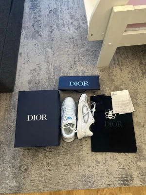 Reflectiva vita skor - Stilrena vita sneakers med sportig design och moderna detaljer. De är gjorda av en kombination av mesh och läder för komfort och bra andningsförmåga. Reflekterande detaljer ger en extra snygg touch.