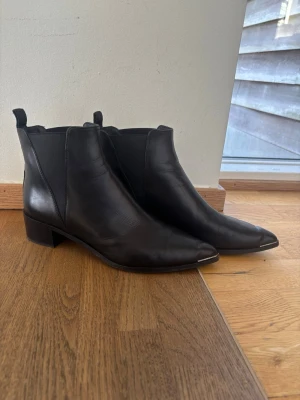 Acne chelsea boots - Acne studios Chelsea boots i läder, modell Jensen. Elastiska paneler på sidorna och dragflikar bak. Spetsig tå med låg klack (4cm). 