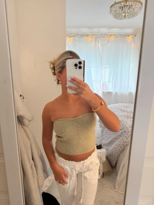 Zara Ljusgrön stickad bandeau tubtopp - Trendig ljusgrön stickad bandeau tubtopp med ribbad detalj framtill. Toppen är axelbandslös och croppad, perfekt för varma dagar och enkel att styla med olika accessoarer.