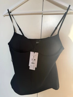 Soft Singlet från Gina Tricot - Snygg svart singlet från Gina Tricot. Strl M, helt ny med prislapp dessutom helt slutsåld.