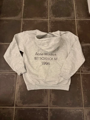 Acne studios hoodie - Riktigt fet och eftertraktad hoodie med Acne studios loggan. Storlek S, skick 10/10!! längd cirka 62cm, bredd cirka 48cm. Obs! Saknar lapp i nacken så är lite osäker på äktheten så därför är priset just nu på 999kr! Nypris runt 7000! Tveka inte med att ställa frågor!