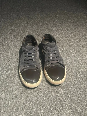 Lanvins  -  Skick: Mycket bra Storlek: 43 Färg: Marinblå/mörkblå  Säljer ett par Lanvin skor som är enkla att matcha och funkar till det mesta. Skorna är i mycket bra skick och välskötta. Det finns en liten slitning som syns på bild 5, men inget som påverkar helheten alls. Lanvin skorna är även självklart äkta och originalpåsen medföljer. Skriv gärna vid frågor eller om du vill ha fler bilder! 