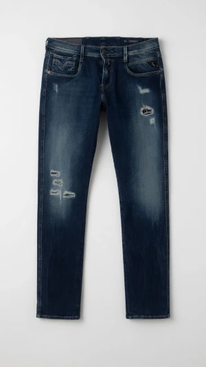 Mörkblå Replay Anbass med slitningar  - Säljer ett par mörkblå jeans från Replay i modellen Anbass  med slitningar och distressed detaljer på låren och knäna. Jeansen har klassisk femficksdesign och smal passform. Perfekt för dig som gillar en avslappnad och trendig look.