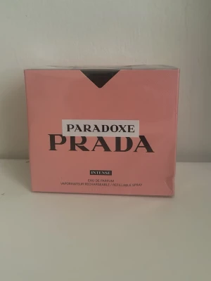 Prada Paradoxe Intense EdP - Prada Paradoxe Intense Eau de Parfum är en lyxig parfym i en elegant rosa förpackning. Doften är intensiv och modern, perfekt för dig som vill sticka ut. Flaskan är påfyllningsbar och designad med stilren känsla. En ikonisk doft från Prada för dig som gillar exklusiva parfymer.