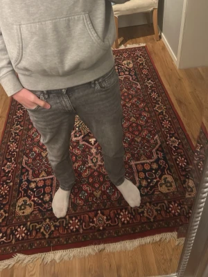 Grå slim fit jeans - Säljer ett par grå slim fit jeans med klassisk femficksmodell och normal midja. Jeansen har en tvättad look och raka ben. Passar perfekt till en avslappnad stil och är lätta att matcha med olika tröjor och sneakers.