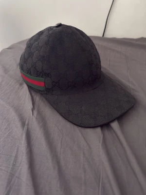 Svart Gucci keps  - Äkta gucci keps använt den lite men den är lite för liten för mig, utan låda, Storlek S 