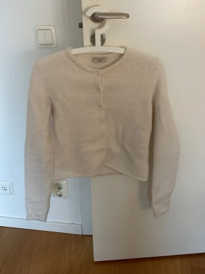 Vit kofta från Gina Tricot XS - Mysig vit kofta från Gina Tricot i premiumkvalitet. Koftan har rund halsringning, långa ärmar och knäpps med vita knappar framtill. Materialet är mjukt och lätt fluffigt, perfekt för lager på lager och en clean look.