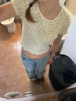 Blommig topp från Brandy Melville - Söt ljus topp från Brandy Melville med små blommor i mönstret. T-shirten har rund halsringning och är kortärmad. Tillverkad i 100% bomull vilket gör den superbekväm och perfekt för varmare dagar😎⛱️