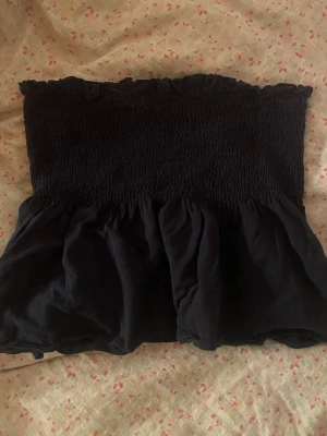 Mörkblå volang tubtopp - Säljer en mörkblå tubtopp med smock upptill och volang nedtill. Toppen är axelbandslös och har en söt, rynkad kant upptill som ger en feminin touch. Perfekt till sommaren att styla med jeans eller kjol för en trendig look. Från SHEIN i storlek S🩶