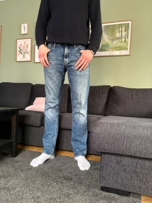 Blå raka jeans från G star  - Ett par klassiska blå jeans med raka ben. Materialet är denim i bomull och de har en tidlös tvättad look som passar till det mesta. Jeansen är i bra skick och inte så använda.