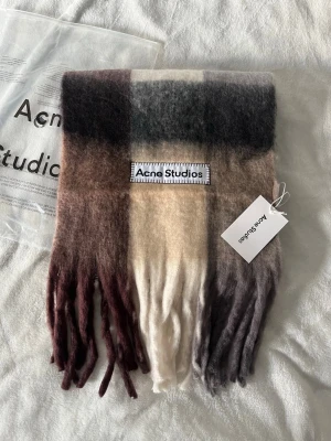 Rutig mohairhalsduk Acne Studios - Supermjuk halsduk från Acne Studios i mohairmix med rutigt mönster i beige, brun, svart och vinröd. 😊