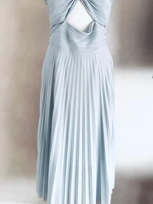 Ljusblå långklänning med plissering - Säljer en elegant ljusblå långklänning med plisserad kjol och twistad överdel med cut-out detalj framtill. Klänningen har en mjuk, flowy känsla och är perfekt för dig som vill sticka ut. Materialet känns som polyester och modellen är ärmlös.