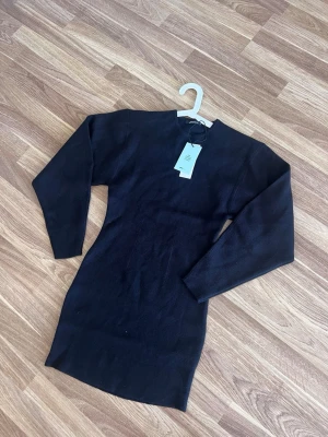 Svart stickad klänning Gina Tricot - Säljer en svart stickad klänning från Gina Tricot i storlek XS. Klänningen har lång ärm och en enkel, tight passform med rund halsringning. Perfekt för dig som gillar stilrena och bekväma plagg. Nypris 499kr!