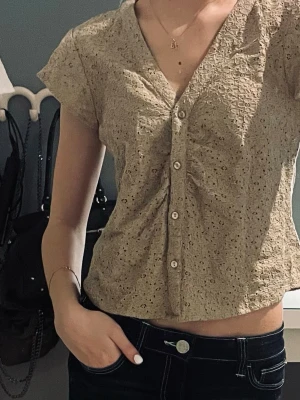 Kakhi färgad jättesöt blus med knappar - Söt kakhi färgad blus med korta ärmar och v-ringning. Jättefint skick, inga defekter alls! Vet ej märket då den är köpt begagnad 🫶🏼