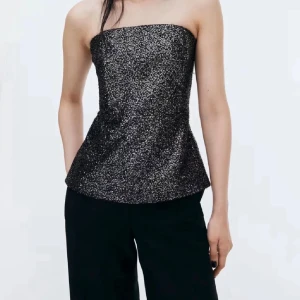 Glittrig svart axelbandslös topp - Säljer en snygg svart tubtopp från H&M, täckt med glittriga paljetter över hela. Utsvängd form nedtill. Köptes inför nyår 2024 men fann ett annat alternativ. Stängs med dragkedja i sidan. Ordinarie pris var 299kr💞🌻