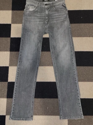 Replay jeans - Säljer ett par gråa Replay jeans, modell Thad. Jeansen har snygga slitningar för en avslappnad look. Materialet är mjukt denim med lite stretch för extra komfort. Perfekta till en chill outfit