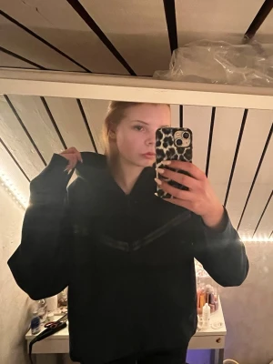 Svart hoodie med dragkedja från Nike (passar både Man och Kvinna!) - Säljer en svart Nike hoodie med dragkedja! Snygg och bekväm köpte för ca 3-4 års sen på JD sports. Den är använd men bra skick, den är i L men är mer som S-M eller 170! Säljer då den ej kommer till användning, köpte för 1399kr 
