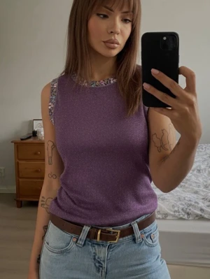 Partytopp från 90-talet ✨ - Från märket Progress Womenswear som är wtt klädmärke som såldes i Europa, särskilt under 1980- och 1990-talet.	Glittrigt lila tyg lurex/metallic stickat med handsydda paljetter och pärlor runt halsen 	En	typisk  party-topp från 90-talet