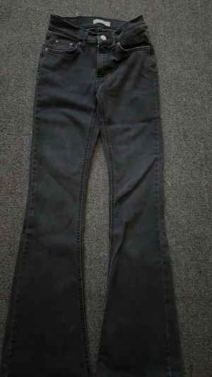 Låg midja mörk grå bootcut jeans - Snygga mörk grå bootcut jeans med låg midja från Gina tricot. Byxorna ser mörka ut pågrund av ljuset. Köpte för 499kr