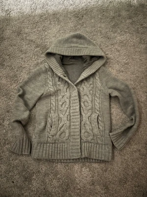 Stickad Cardigan - Snygg och bekväm stickad cardigan i storlek S. Passar till både vardag och lite finare tillfällen. En knapp saknas, därav ett lägre pris, dock ingenting som enligt mig påverkar funktionen alls. Bortsett från det så säljs den i ett väldigt bra skick. Mått: längd-57 cm, bredd 40-cm. Hör gärna av dig vid frågor eller intresse! Mvh:Axel 