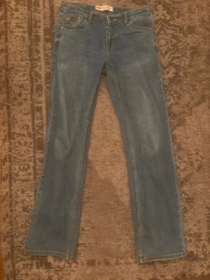 Levi's 517 blå bootcut jeans - Klassiska blå Levi's 517 jeans med bootcut passform och fem fickor. Jeansen har den ikoniska röda Levi's-lappen på bakfickan och patch i läder bak i midjan. Tillverkade i slitstark denim med snygga kontrastsömmar.