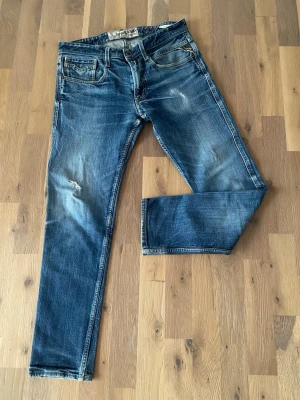 Replay Anbass - Säljer ett par blå jeans från Replay, Anbass modellen. Jeansen har snygga slitningar och har en lite tajtare passform. Det är storlek 31 i midjan och tjugonio i längd.