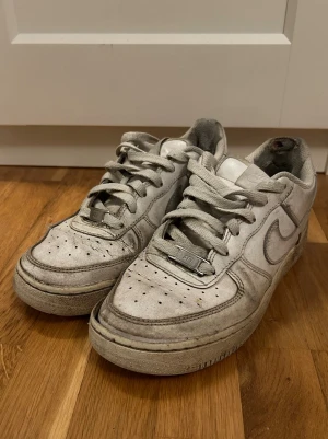 Nike Air Force 1 vita sneakers - Klassiska vita Nike Air Force 1 sneakers. Dem är väldigt använda och slitna men går säkert att få lite renare om man tvättar dom!!🙏🏻 storlek 37,5 passar även 38