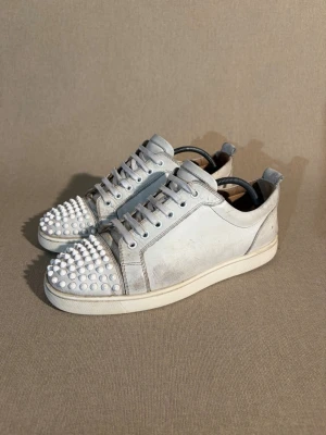 Christian Louboutin Louis Junior - Storlek: 41 EU = 7/7,5 UK | Färg: Vit | Skick: Okej skick | Defekter: Slitage på lädret, vissa spikar är slitna och ytter sulan är sliten | Material: Läder | Tillbehör: Inget | Pris: 2499kr | Dm för frågor.