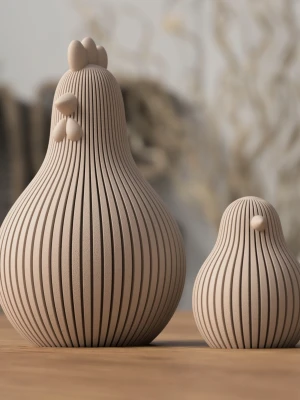 Dekorativa hönor i beige  - Två stilrena prydnadshönor i beige med räfflad yta och minimalistisk design. Perfekta som inredningsdetaljer på bord eller hylla. Hönorna har rundad form och enkla detaljer för näbb och kam.