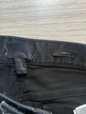 Svarta jeans från H&M - Säljer ett par svarta jeans från H&M. Jeansen har klassisk femficksdesign, smal passform och normal midja. Materialet är stretchigt för extra komfort. Perfekta för en clean och stilren look.